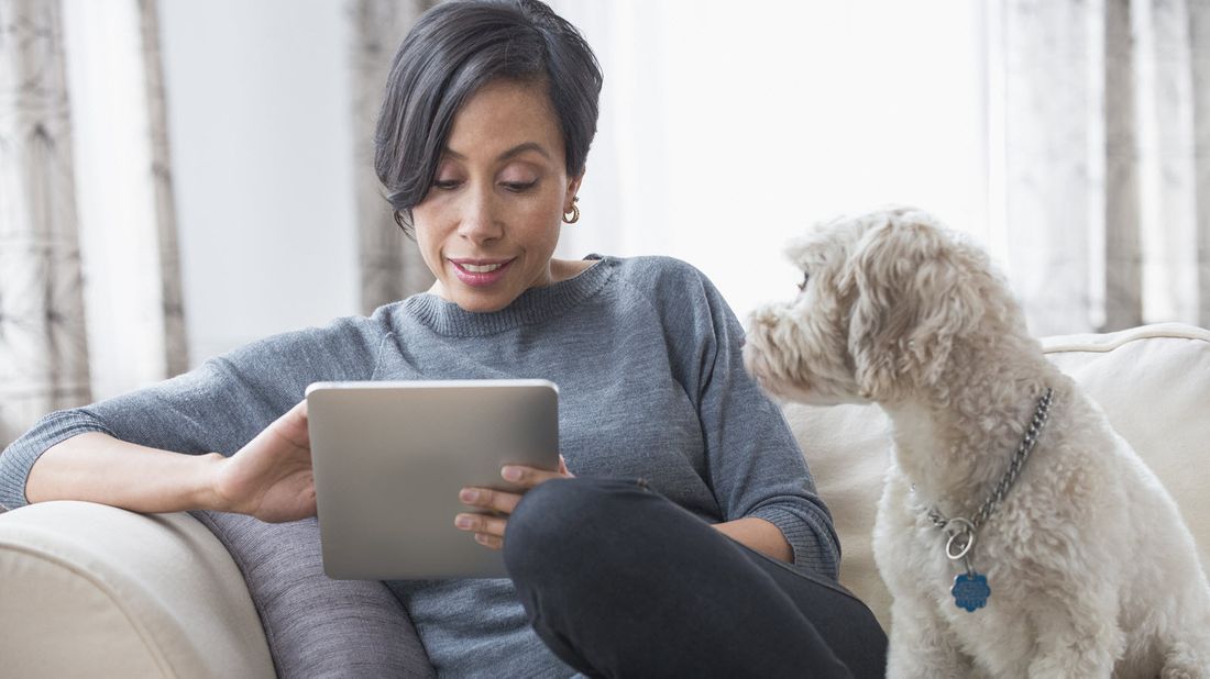 Woman sitting on couch reading Northwestern Mutual Market Commentary