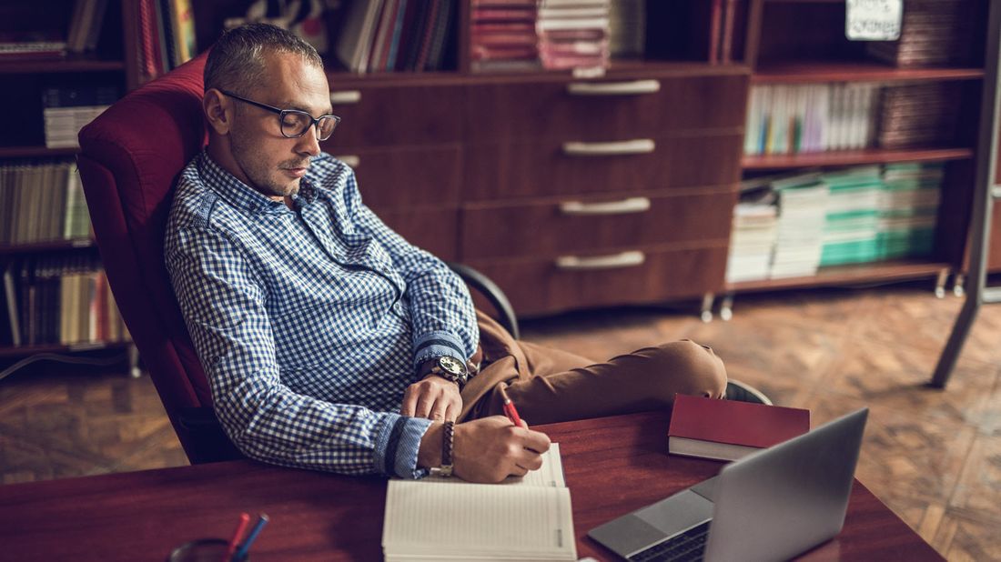 Man taking notes at his desk.