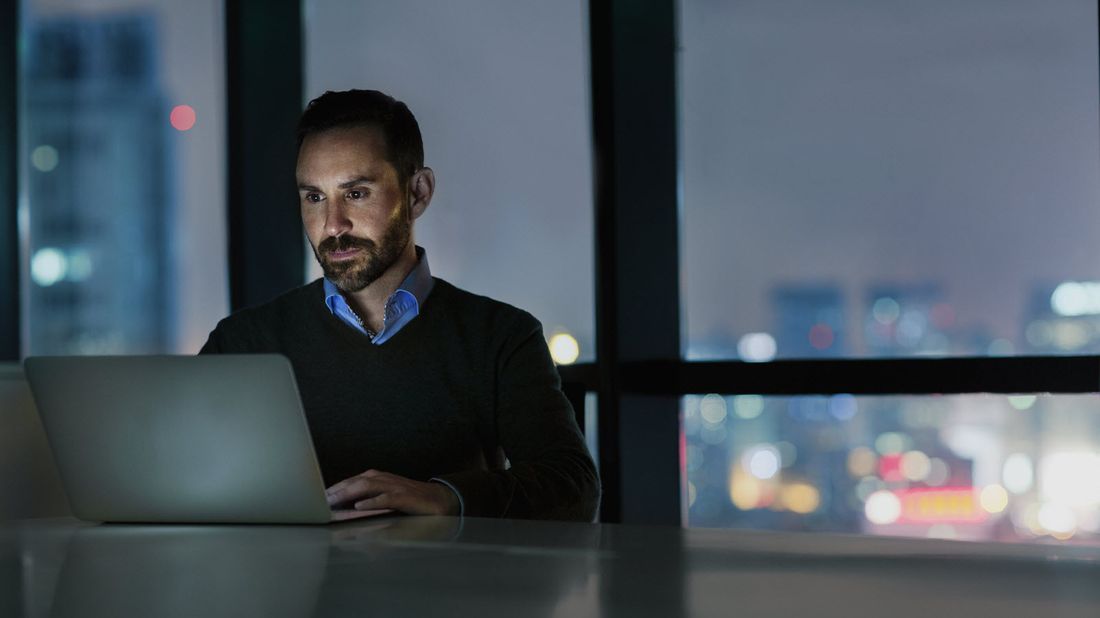 Man sitting at a table reading Northwestern Mutual Market Commentary