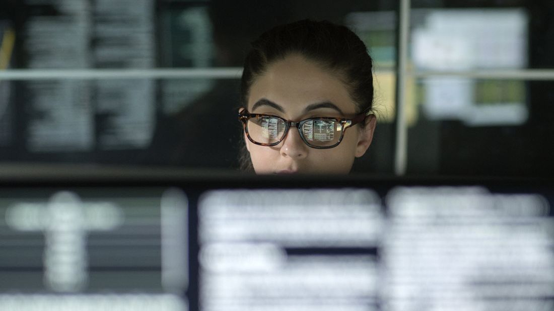 A market analyst studies data on a computer screen