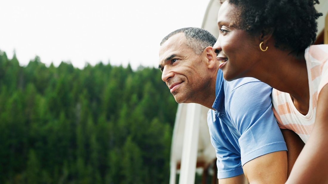 Couple on deck of boat looking at view