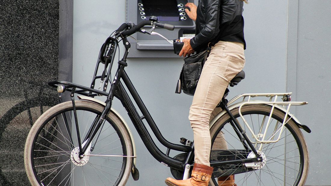 woman on bike using atm