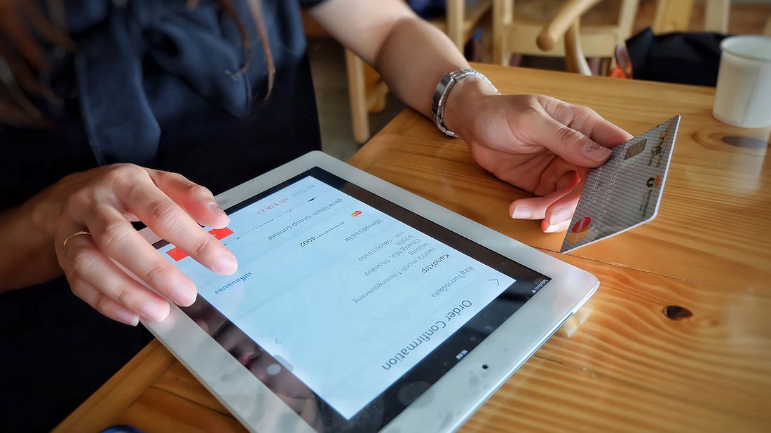 woman shopping on ipad with credit card in hand