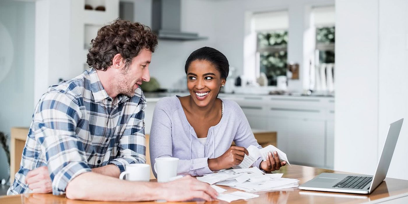 Couple at a table discussing the financial steps to take before applying for a mortgage