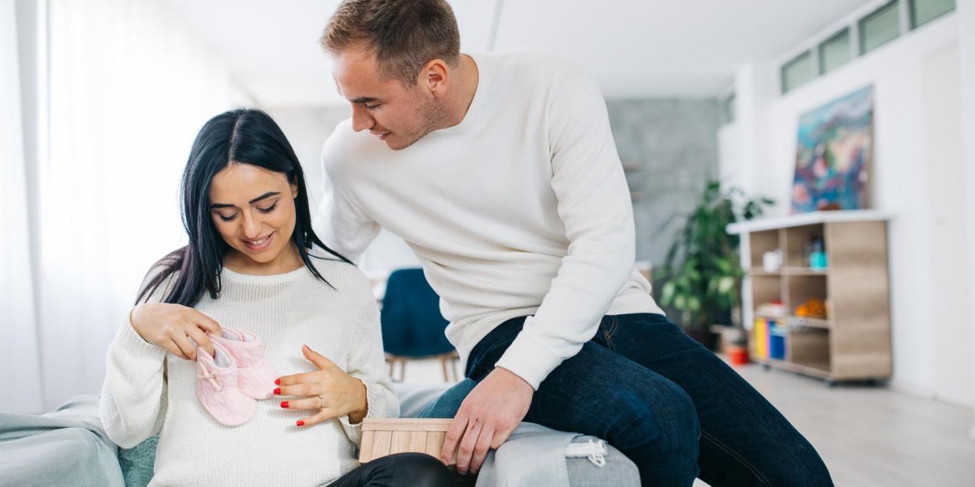 Pregnant women and man buying baby gear in May
