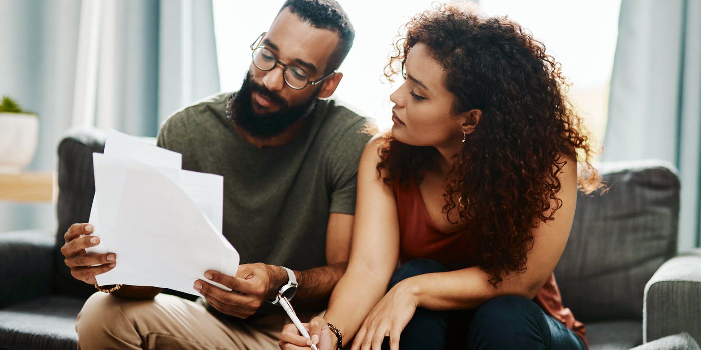 Couple looking at paperwork while filing their taxes before the July 15th tax deadline.