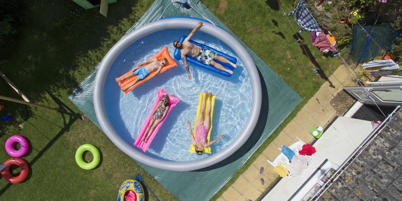 family in large padding pool in upgraded backyard