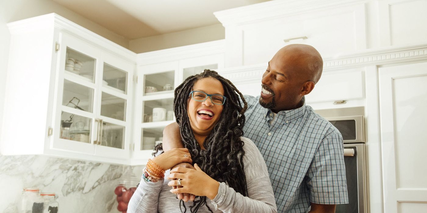 Couple in the kitchen talking about how much money they need to retire at age 50.