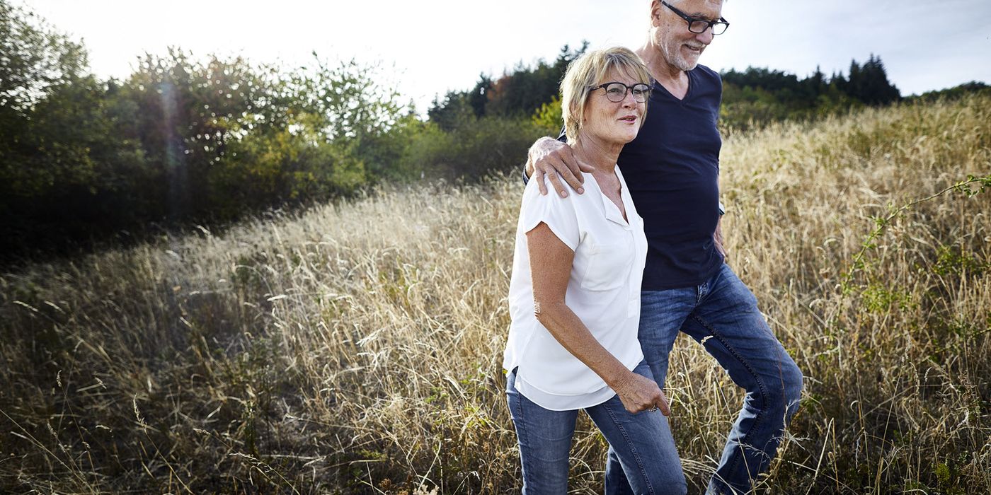 Couple walking in a field discussing when can I take money out of my 401(k)