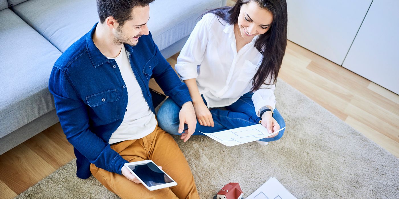 Couple with floor plans going on virtual home tour