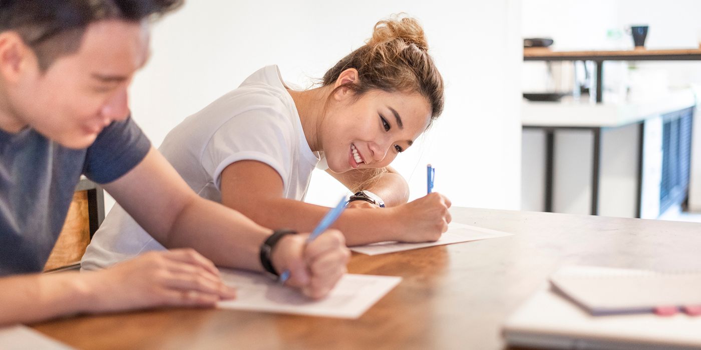 Couple writing personal letter to home seller.