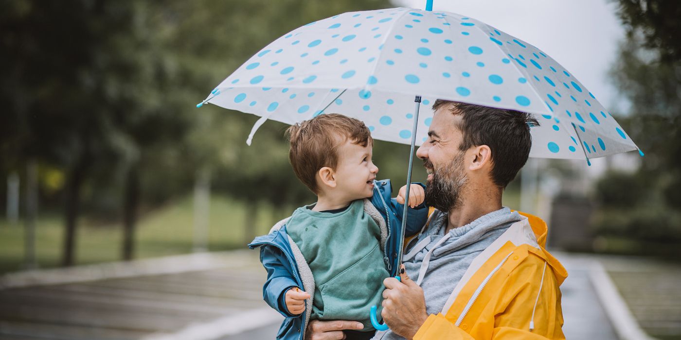 father and son holding umbrella