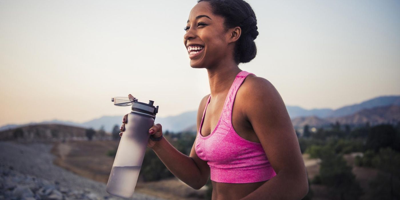 woman with water bottle pursuing wellness goals