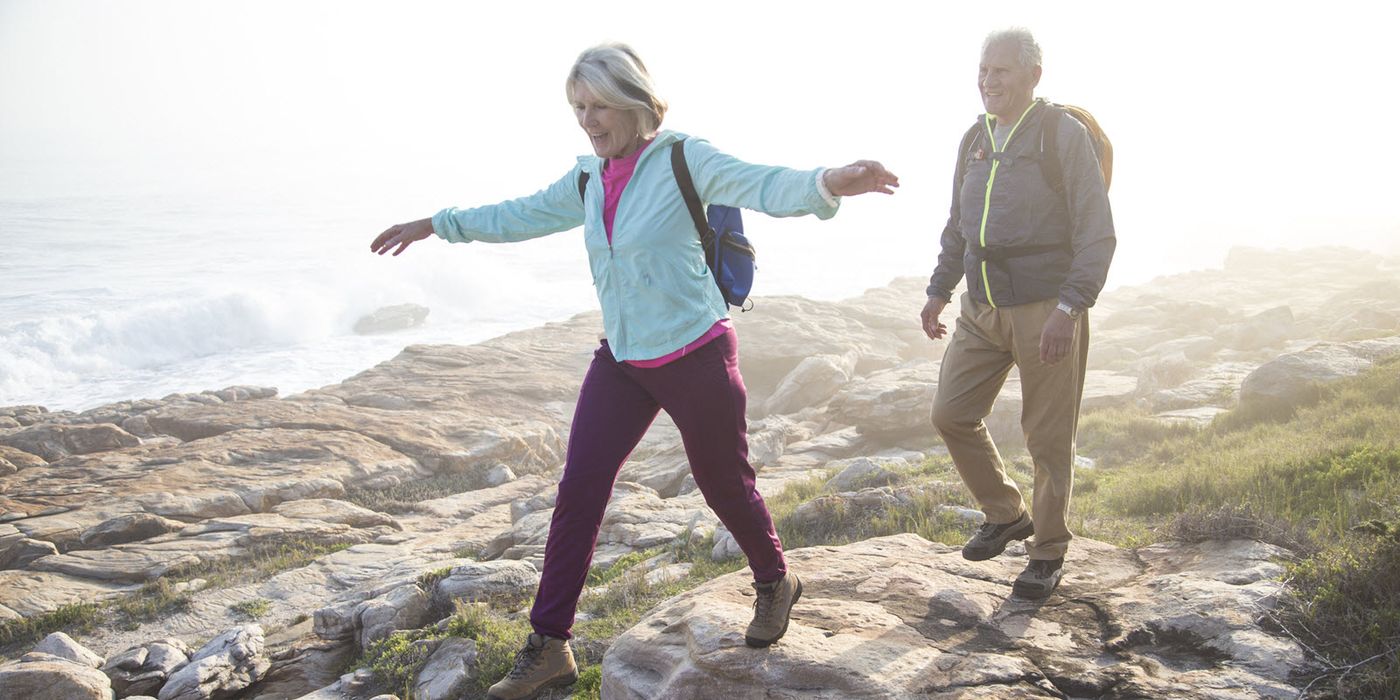 Active retired couple enjoying a hike over a rocky shoreline