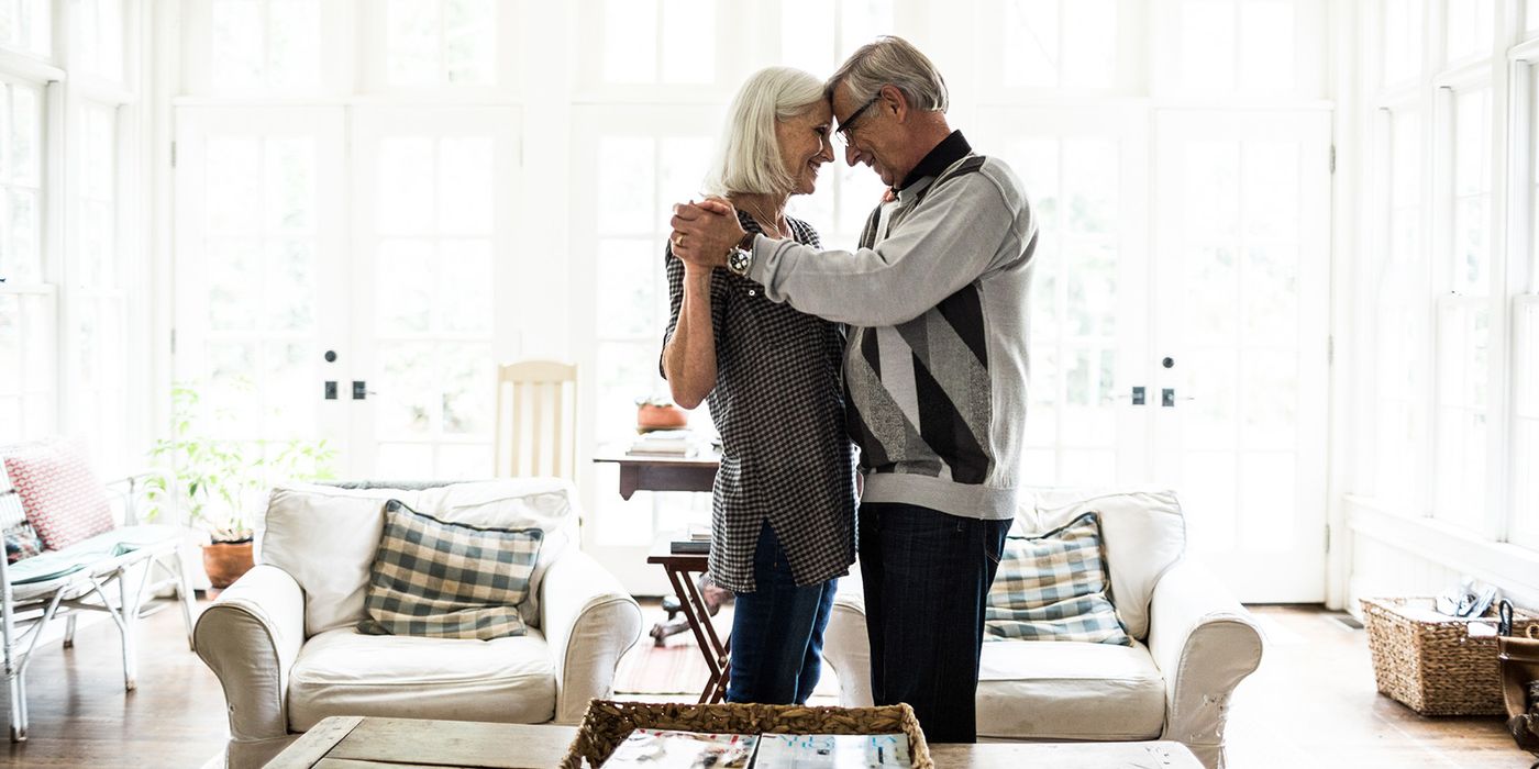 senior couple dancing in living room