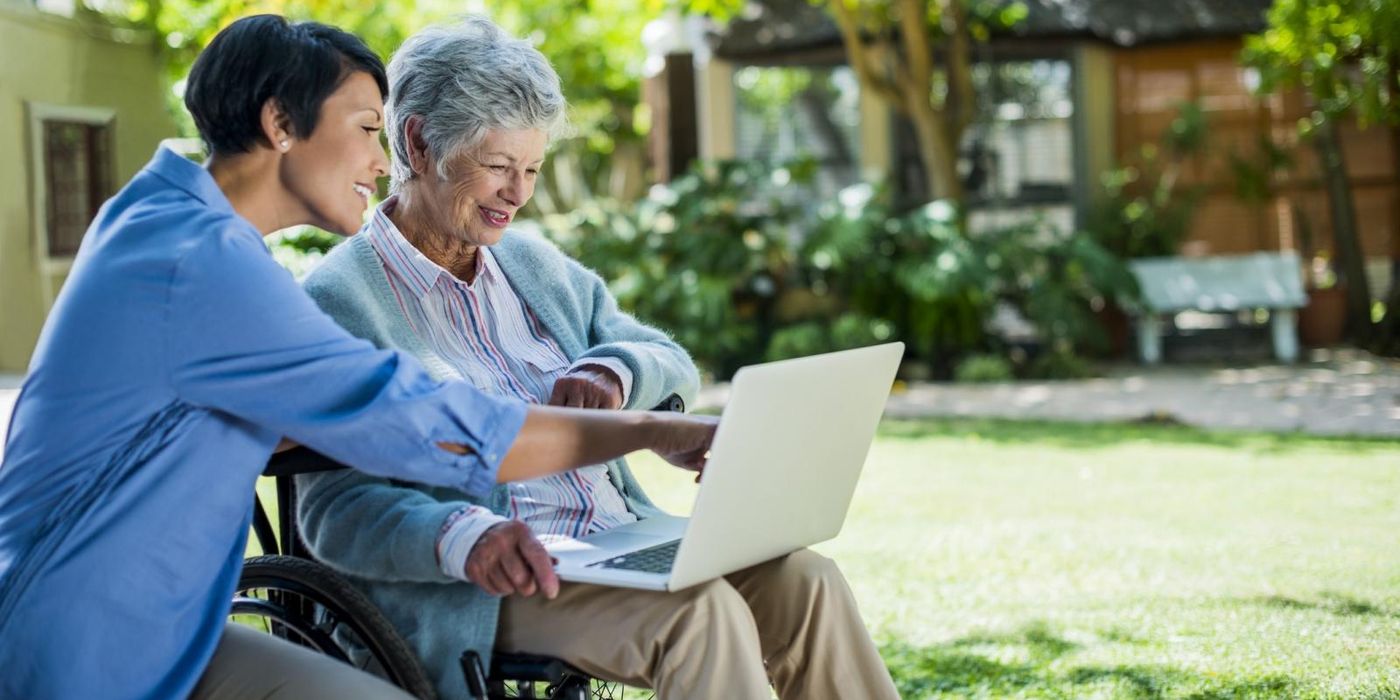 Long term care worker helping elderly woman.