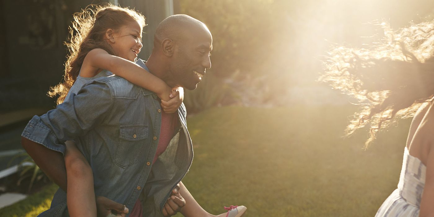 Man playing with kids in backyard wondering how much life insurance he needs.