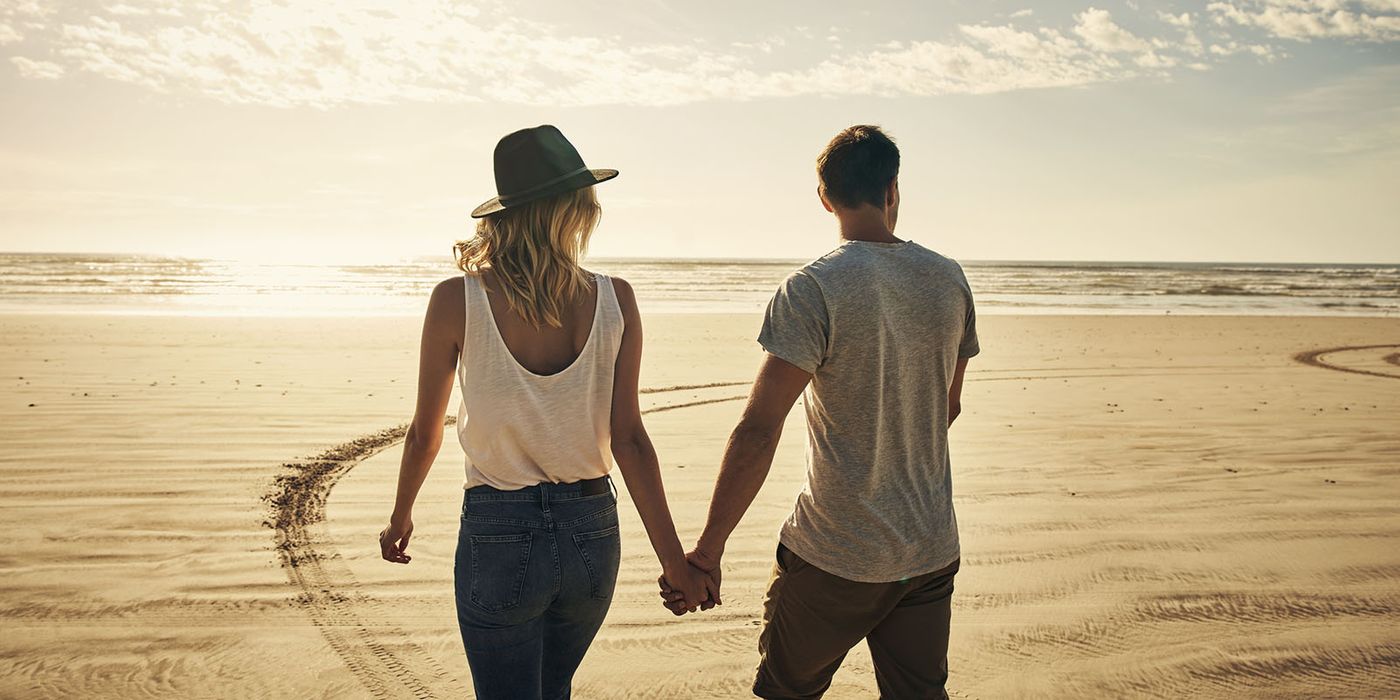 couple walking on beach talking about finances