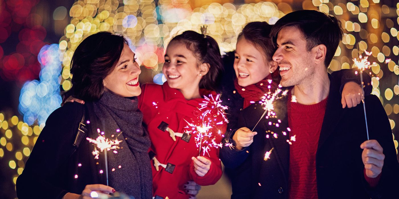 Family holding sparklers as they consider their financial goals for 2018.