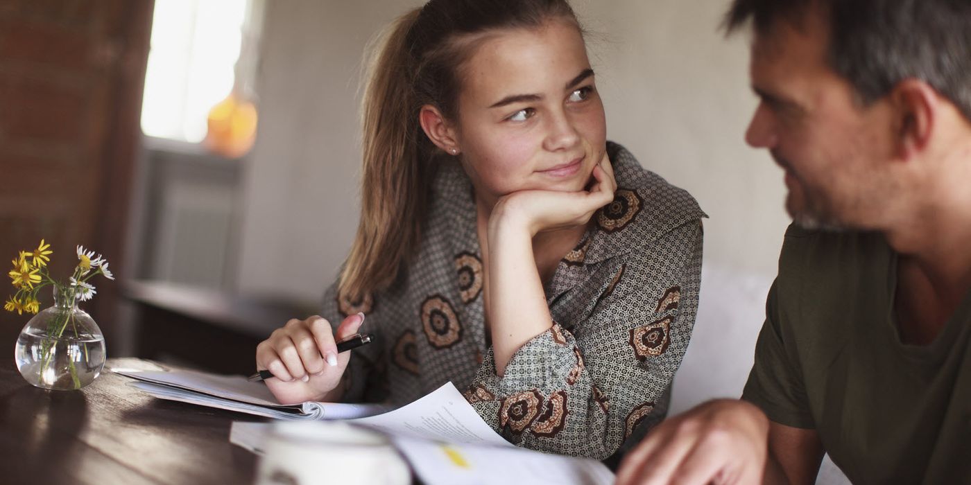 Dad at a table asking his daughter financial questions before they decide on a college