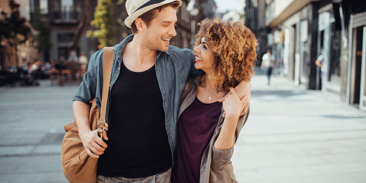 couple walking on street with arms around each other