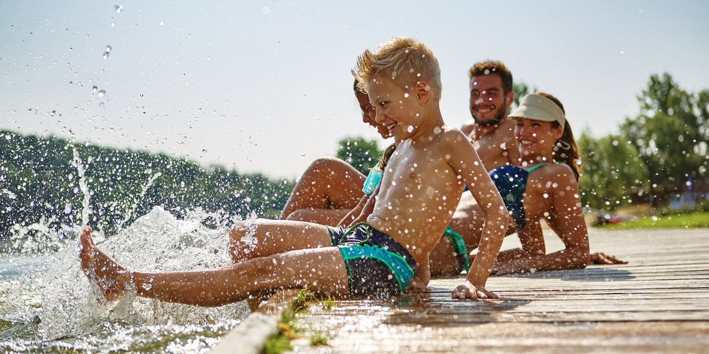 Family on the dock at a lake.