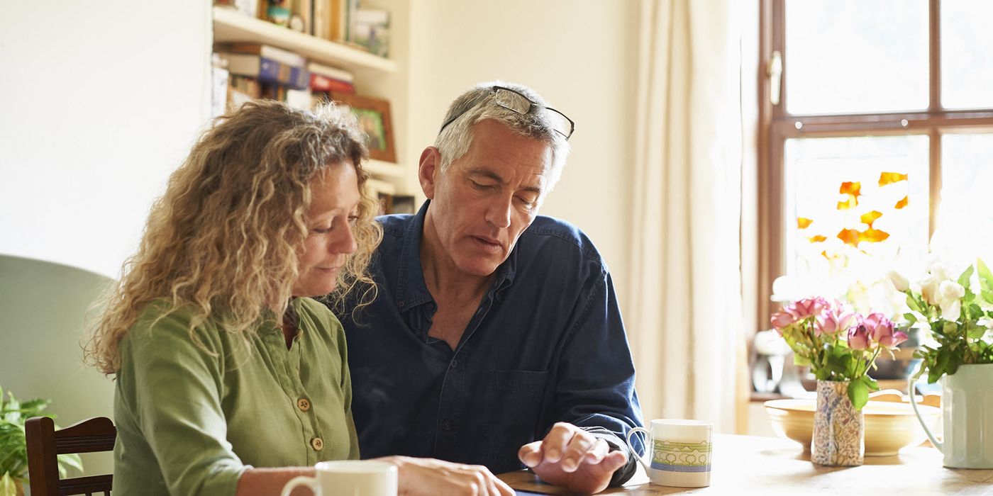 Couple looking at tablet and discussing the high cost of health care in retirement.