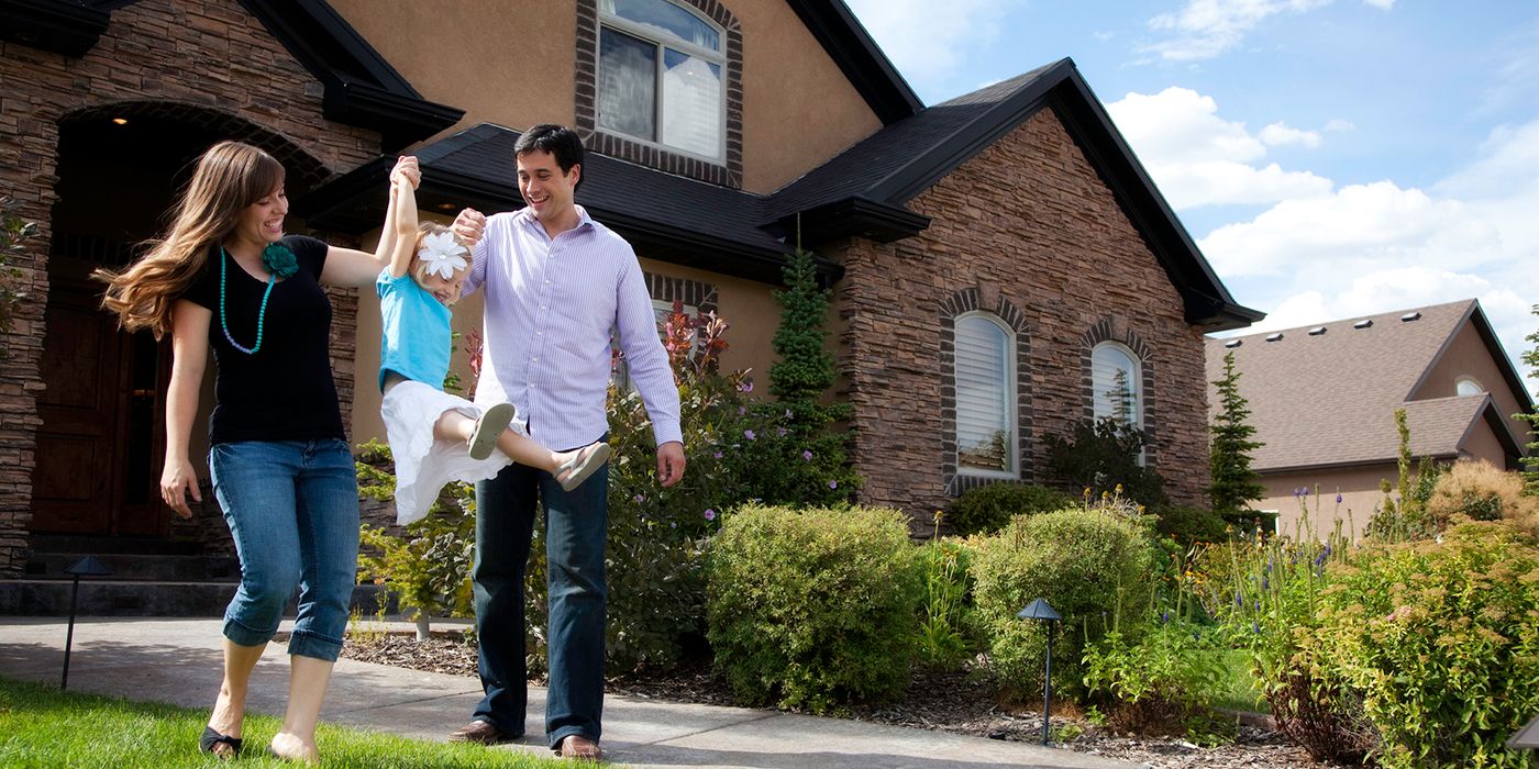 Family in front of home planning to refinance their mortgage.