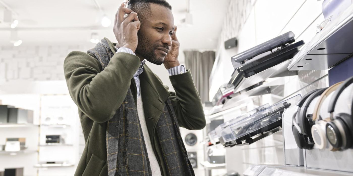 Man trying on headphones in a store in March