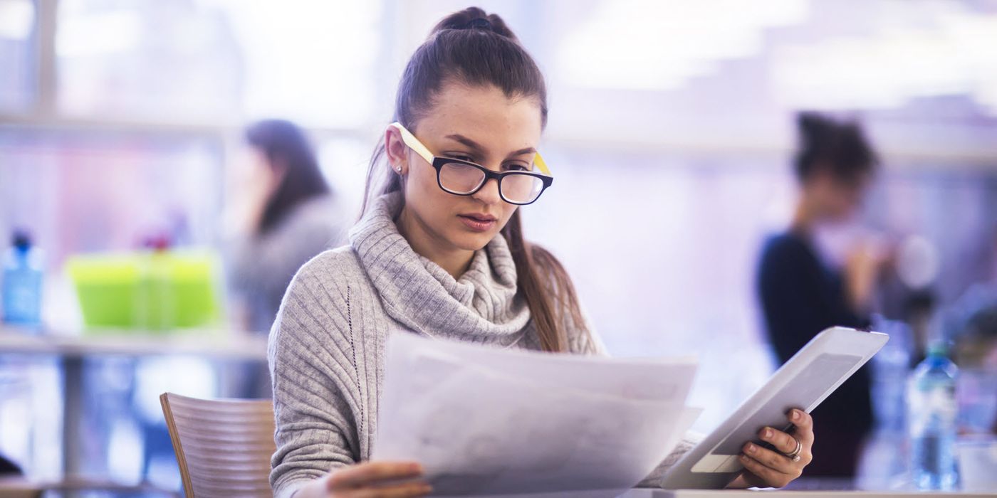 Woman looking at papers trying to determine the difference between an FSA vs. an HSA.