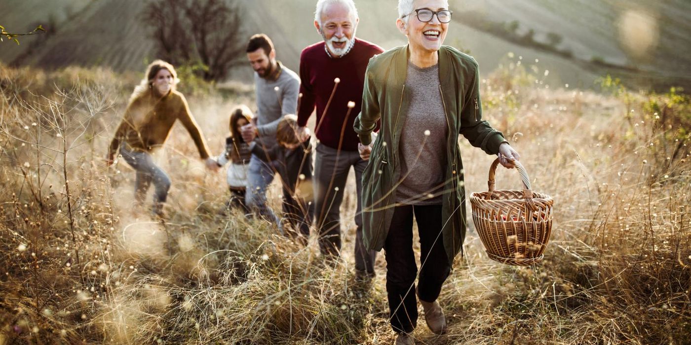 Senior woman with family climbing hill in dream retirement