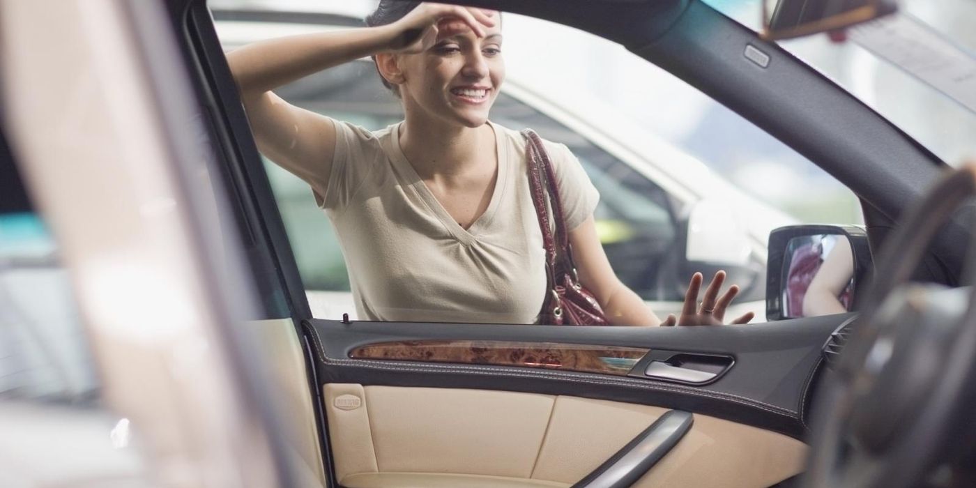 woman-looking-into-car-on-dealer-lot