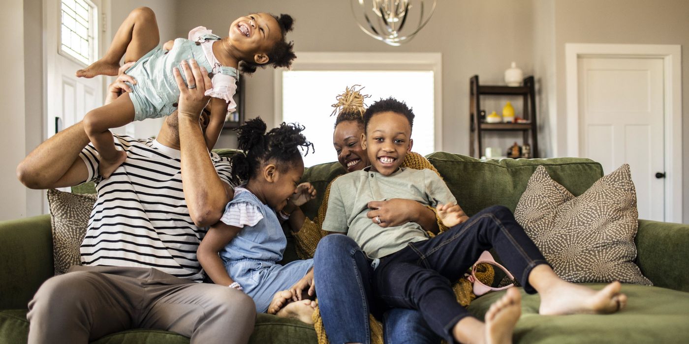 Family on a couch talking about cash value life insurance.