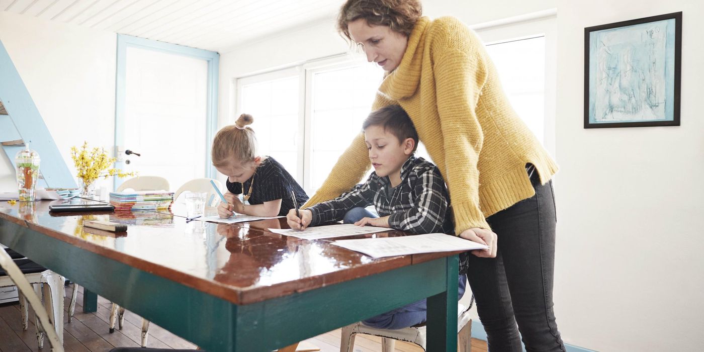 Mom studying with kids at table to prep them for college in the future