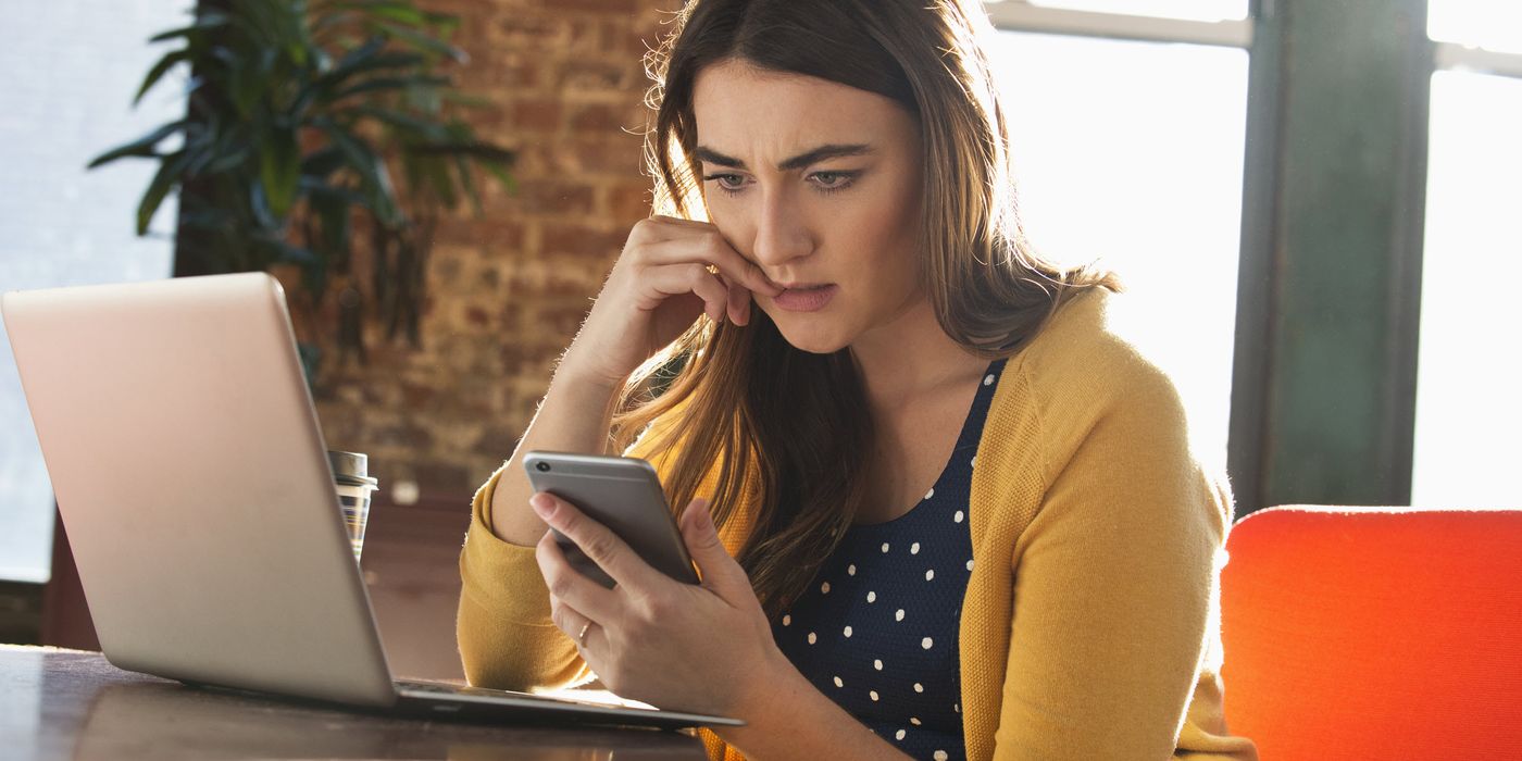Woman looking at her phone reading about interest rates going up.