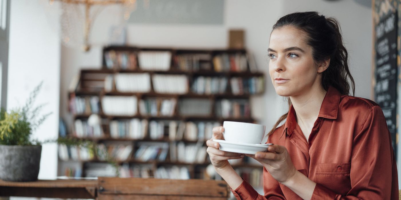 Woman drinking coffee thinking about how to prepare for a recession