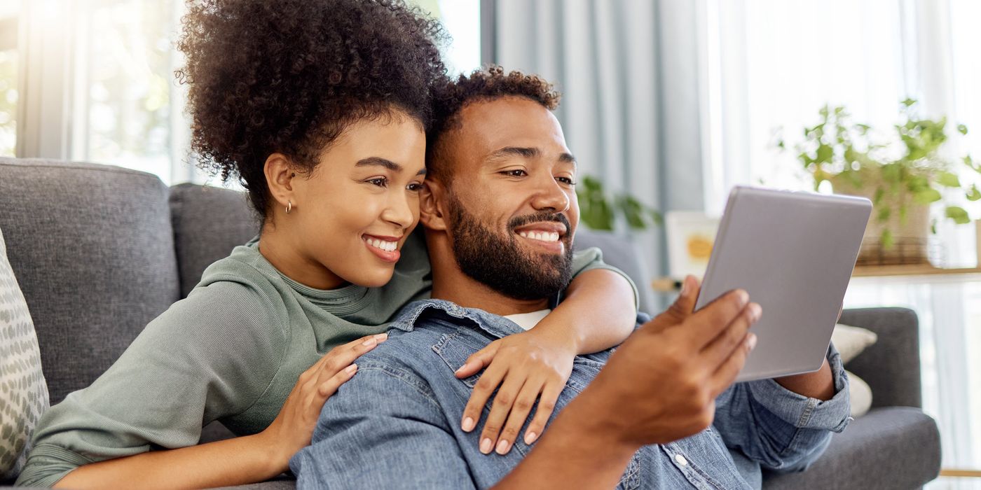 Couple reading on a tablet about how much to save in an emergency fund