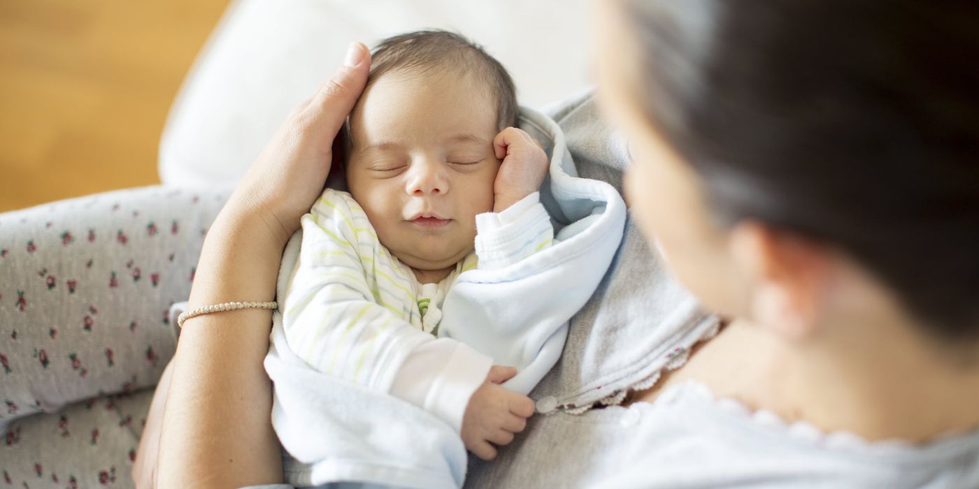 a woman holding a newborn baby