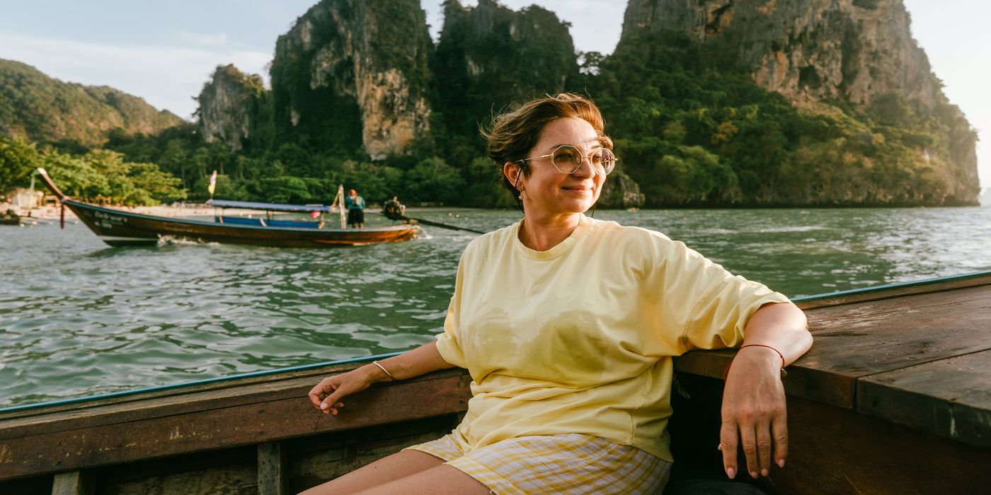woman smiling and enjoying a boat ride on a solo trip