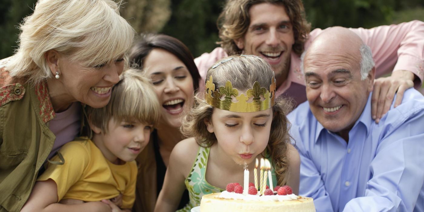 Young girl celebrating birthday with family and cake