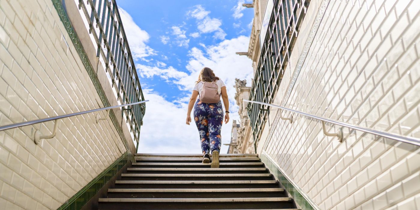 Walking up the stairs of the subway while carrying a backpack 