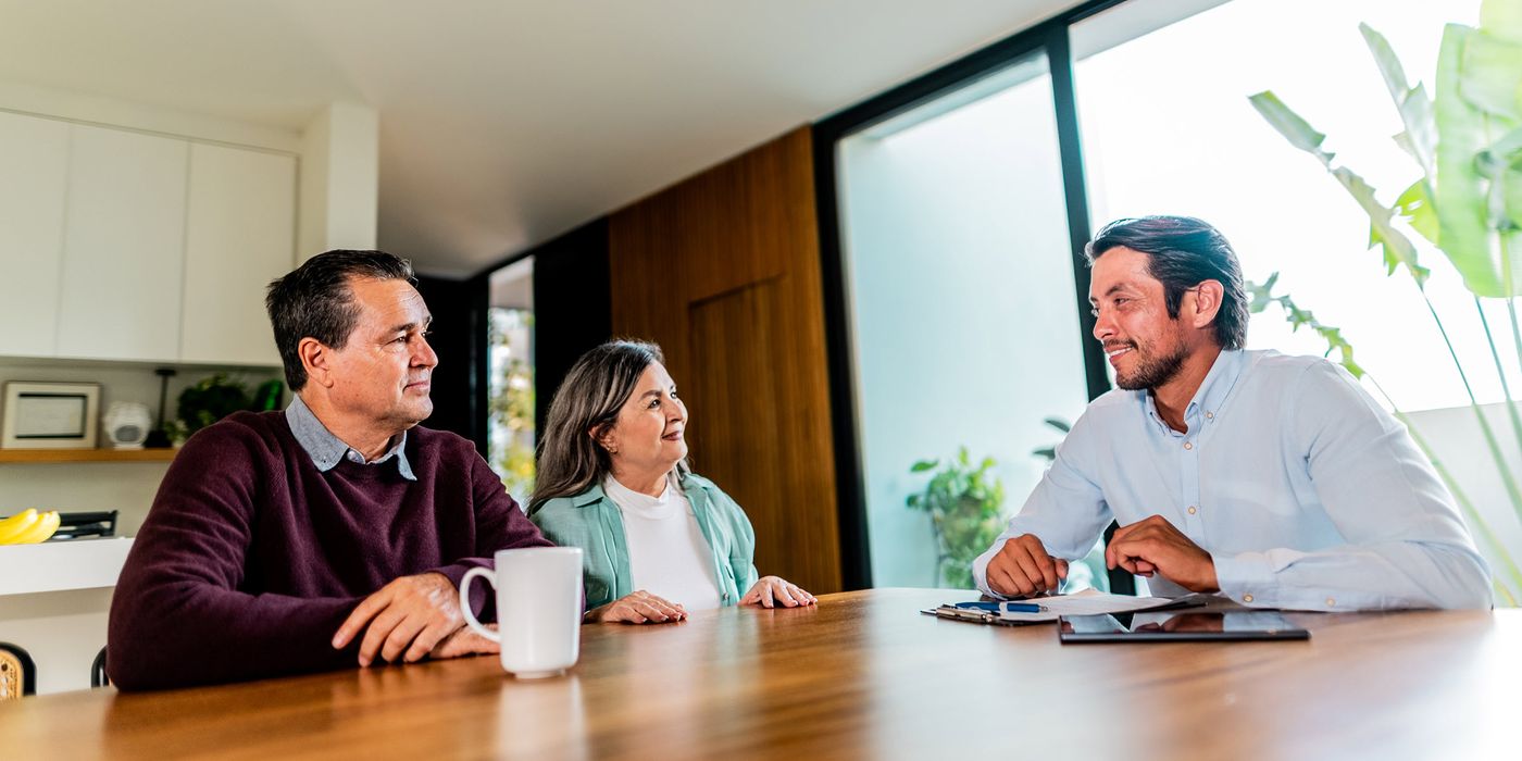 Couple talking to real estate agent at house