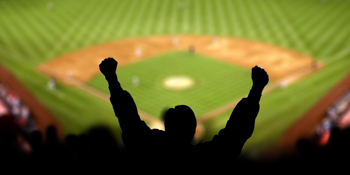 Fans lifting hands in celebration at a baseball game