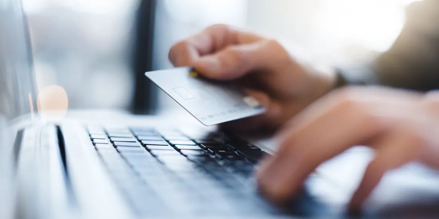 Man holding credit card while using a computer