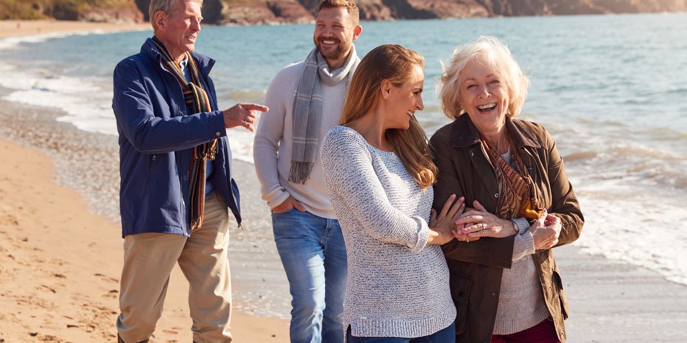 couple-walking-on-beach-with-adult-offspring