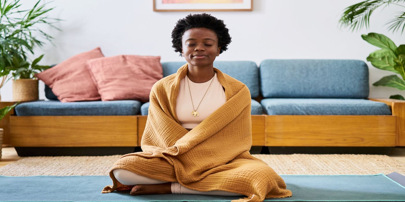 A woman meditating with a blanket