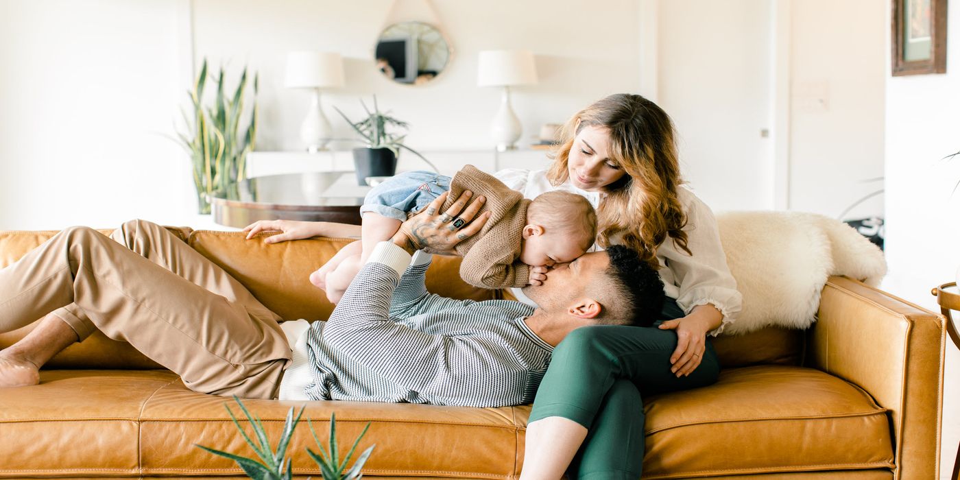 Couple relaxing on a sofa with baby