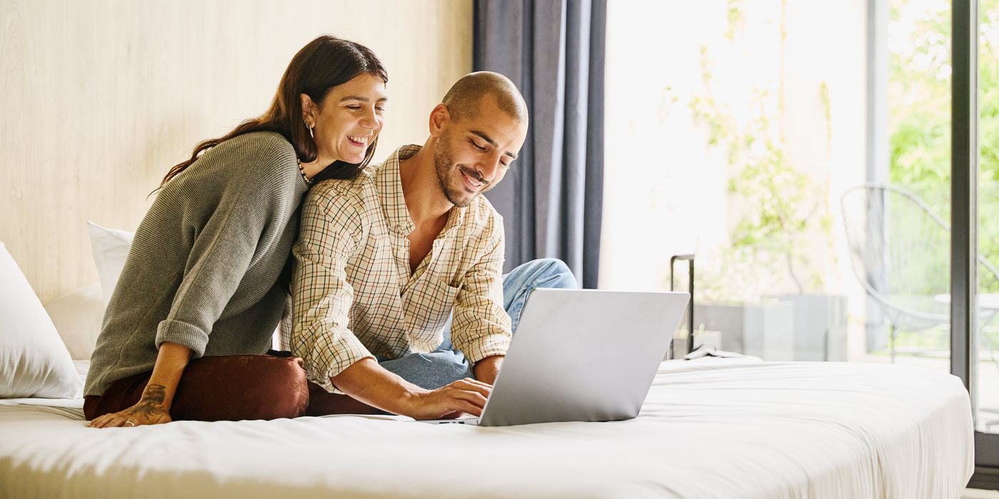 Shot of smiling couple planning finances on laptop