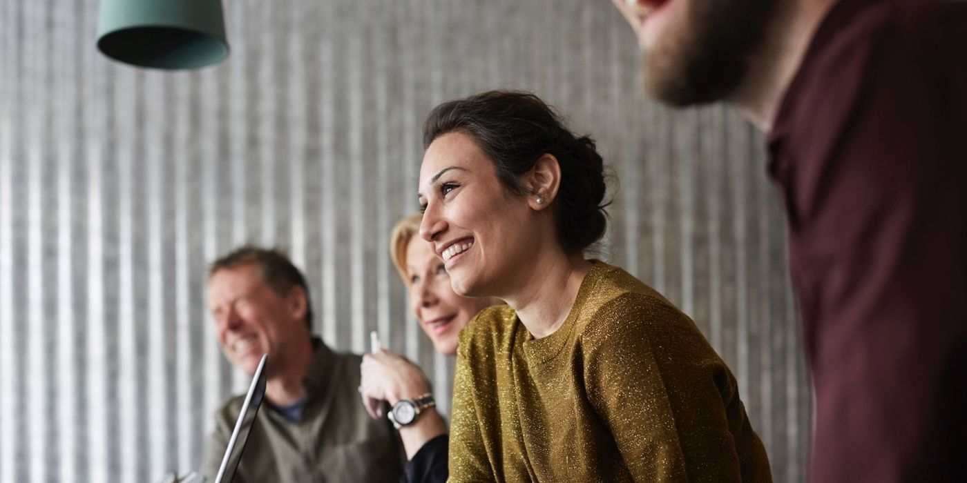 Woman in business meeting smiling.