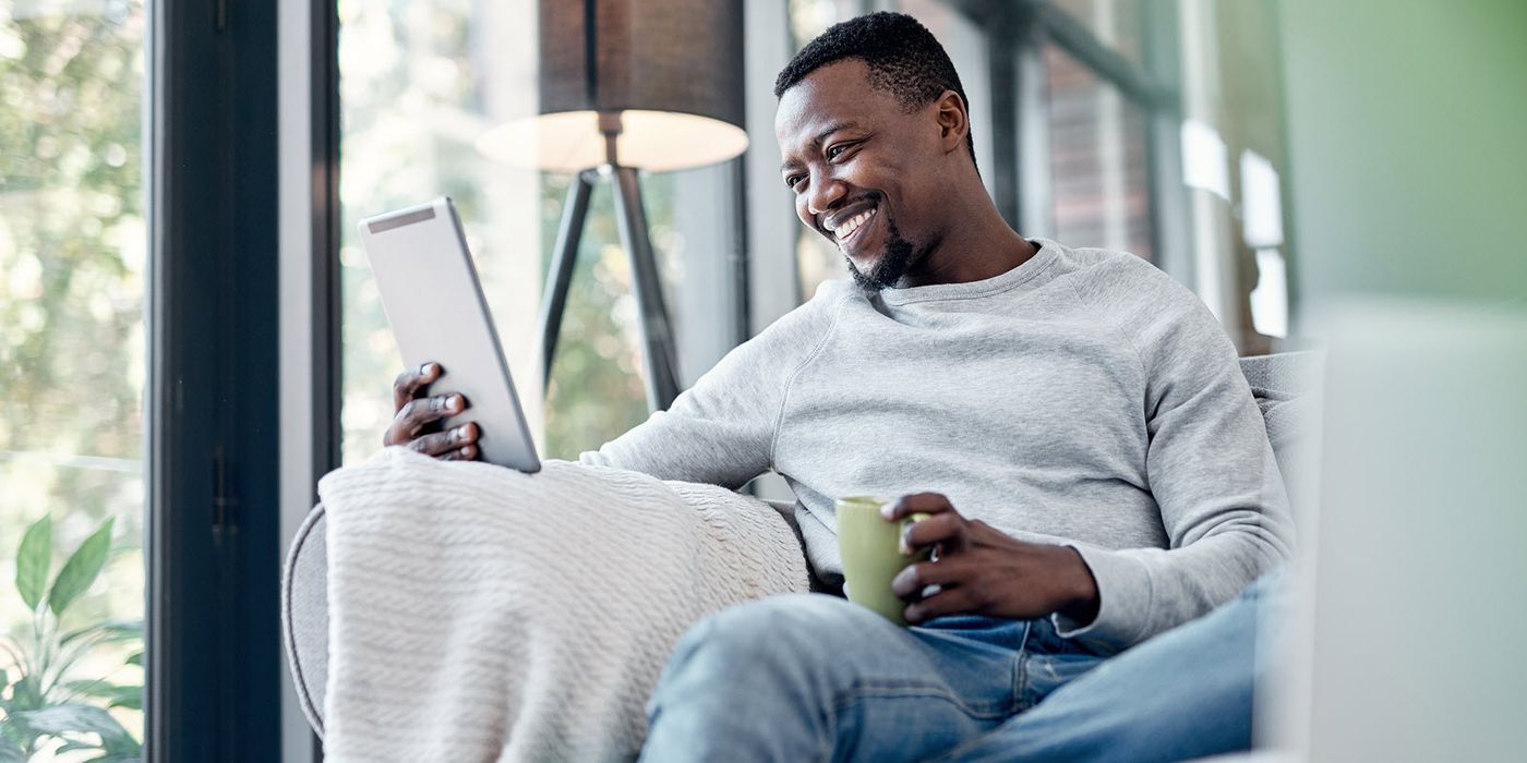 Man drinking coffee and reading Northwestern Mutual Market Commentary